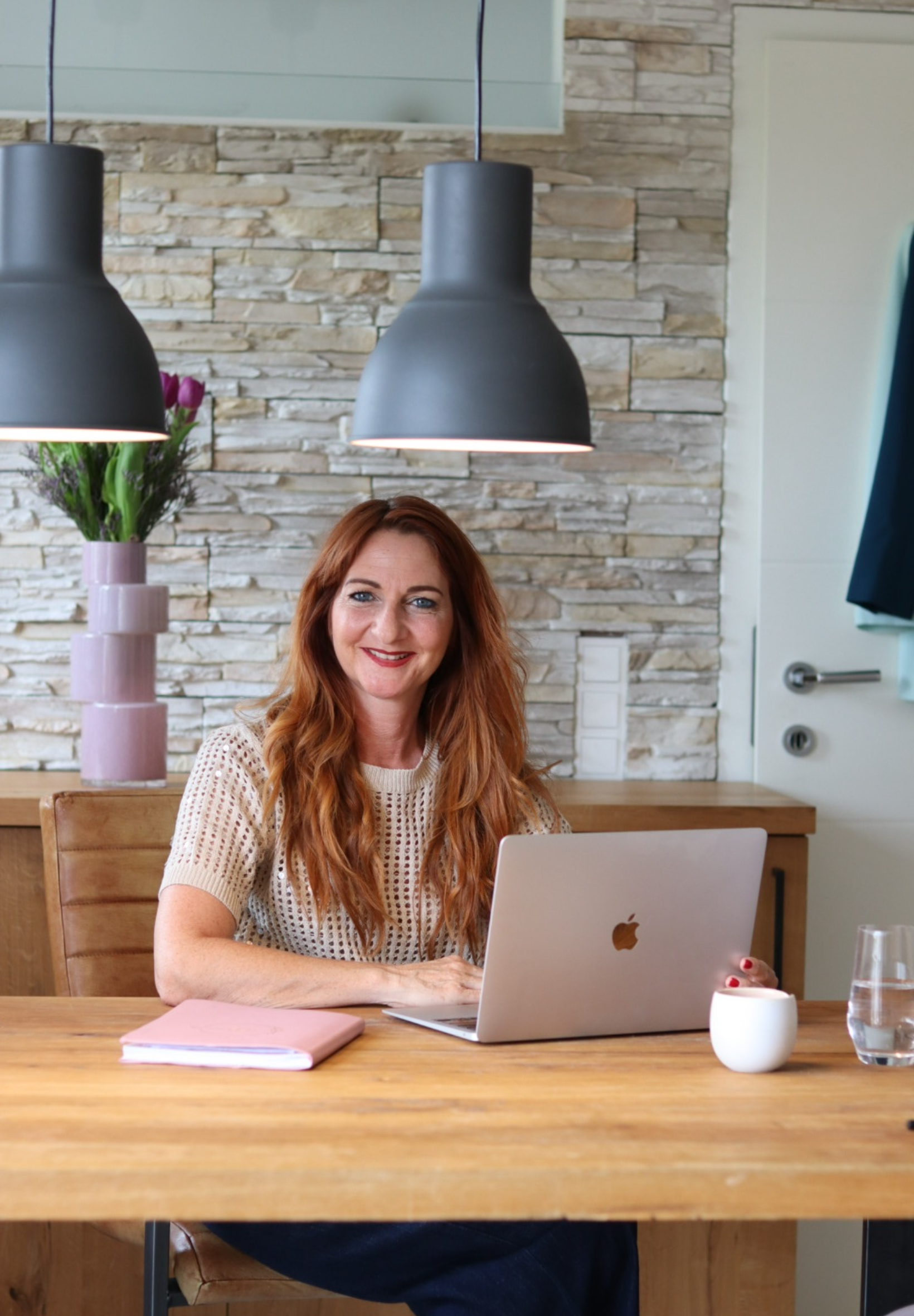 Karina sitzt mit ihrem Laptop an einem Tisch